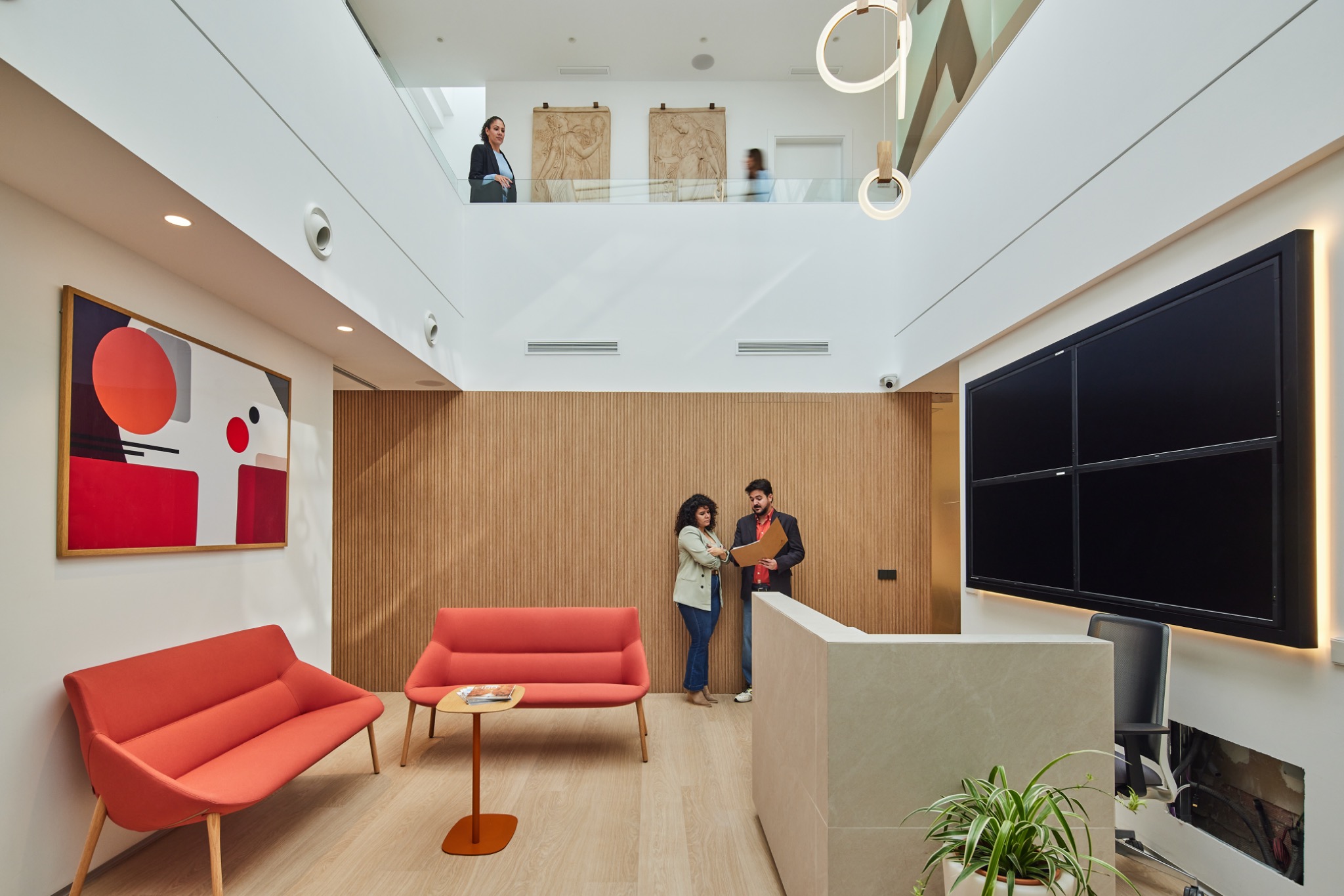 Nuestra recepción y zona de espera con asientos rojos